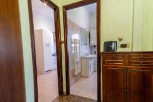 罗马Light Blue Apartment - City Center Rome的厨房设有一扇门,通往带电视的厨房