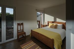蓬塔德尔加达Quinta do Ferreiro的卧室配有床、椅子和窗户。