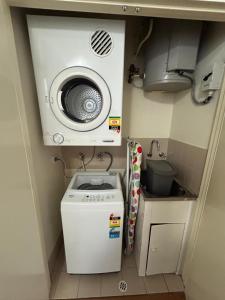 珀斯Narnia in Northbridge - One Bedroom的小厨房配有洗衣机和水槽