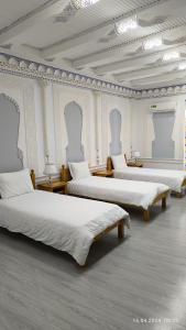 撒马尔罕比比克哈努姆酒店的白色墙壁的客房内的三张床
