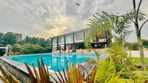 勒克瑙Vintclub Resort的一座房子前面设有游泳池