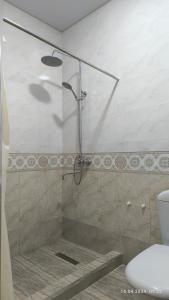 撒马尔罕比比克哈努姆酒店的浴室里设有玻璃门淋浴