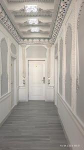 撒马尔罕比比克哈努姆酒店的一条带白色门和天花板的走廊