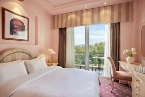 塞萨洛尼基帕诺拉玛酒店的一间卧室配有一张床、一张书桌和一个窗户。