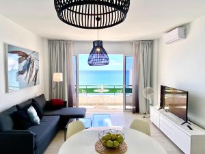 圣巴尔托洛梅Lanzarote Frente al Mar的客厅配有蓝色的沙发、电视和桌子