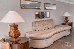 圣何塞圣何塞海瑞德拉温德姆酒店的客厅的沙发,配有台灯
