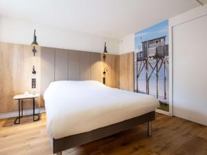 波尔多波尔多中心玛丽亚德克宜必思酒店的卧室设有一张白色大床和一扇窗户。