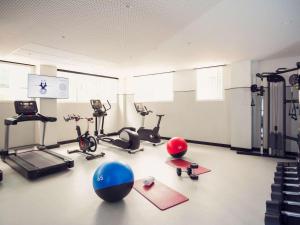 马德里诺富特坎波德拉斯纳西昂酒店的健身房提供健身自行车和运动球,位于地面