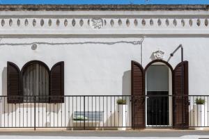 奥斯图尼La Casa Bianca的白色的建筑,设有棕色百叶窗和阳台