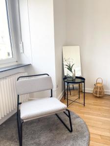 BonnevoieBerchem - Guest House的一张椅子,放在一个镜子和一张桌子的房间