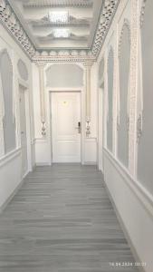 撒马尔罕比比克哈努姆酒店的一条空的走廊,有白色的门和白色的墙壁