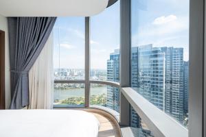 胡志明市Isabelle Luxury Apartment inside Landmark 81 Tower的客房设有床和大窗户。