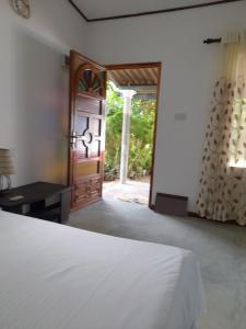 乌纳瓦图纳Aruna Villa的一间卧室设有一张床和一个开放式门