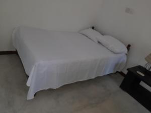 乌纳瓦图纳Aruna Villa的一张白色的床,上面有两个枕头