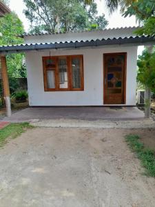 乌纳瓦图纳Aruna Villa的一间白色的小房子,有门