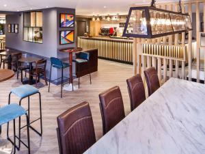 史云顿ibis budget Swindon的一间带桌椅的餐厅和一间酒吧
