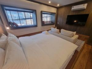 清刊The Folkster House Chiangkhan的卧室配有一张白色的大床和一张沙发。