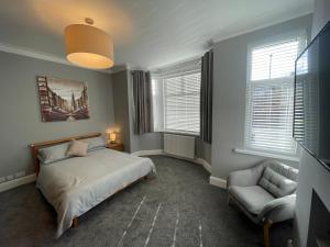 曼彻斯特Delightful home in Manchester的一间卧室配有一张床、一把椅子和窗户。