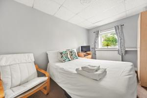 布里格Riverside Mews的卧室配有白色的床和椅子