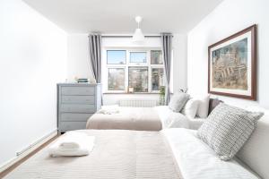 伍德福德格林Stylish flat In London for Tourists, Contractors, Relocators - sleeps 5的一间白色卧室,配有两张床和窗户