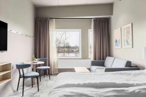 卡尔斯塔德Aiden by Best Western Karlstad Arena的酒店客房带一张床、一张桌子和椅子