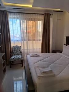 ThikaThe Sailors Address的卧室配有床、椅子和窗户。