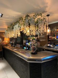 尤托克西特The White Hart Hotel的天花板上挂着鲜花的酒吧