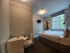 伦敦贝尔格拉维亚酒店的酒店客房,配有床和一张带水果的桌子
