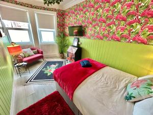 伯恩茅斯Lemur Lodge - Boutique Apartments - Short Stroll to The Beach的一间卧室,拥有带粉红色花卉的绿色墙壁