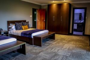 PelindabaLa Joya Lodge Conference Centre and Spa的一间卧室设有两张床和木制橱柜