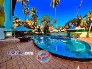 GoaShivam Resort With Swimming Pool ,Managed By The Four Season - 1 km from Calangute Beach的棕榈树度假村的游泳池