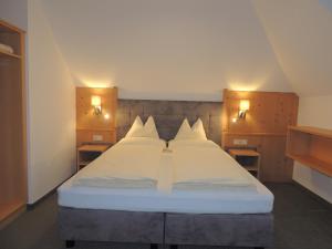 奥伯古格尔克里斯托弗旅馆的卧室配有一张带两个灯的大白色床