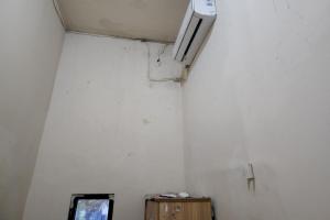 泗水OYO 93865 Dv Homestay Syariah Kupang的一间设有白色墙壁的客房,墙上配有电视