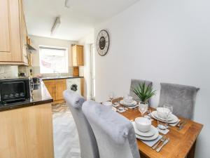 圣海伦斯2 Bed House by AV Stays Short Lets Merseyside的厨房配有带椅子的木桌
