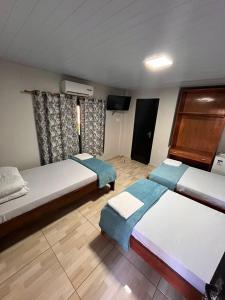 伊瓜苏Pousada Cidade Linda的一间卧室配有两张床和电视。