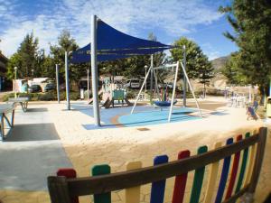 Las Lagunas MijasCasa Ladera的一个带蓝天篷和秋千的游乐场