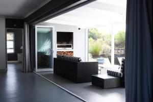 克尼斯纳Ocean View - The Villa的带沙发和电视的客厅以及天井。