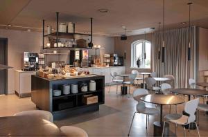 克厄Zleep Hotel Køge的一间在房间内配有桌椅的餐厅
