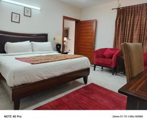 伊斯兰堡Palladium Executive的一间卧室配有一张床、一张桌子和一把椅子