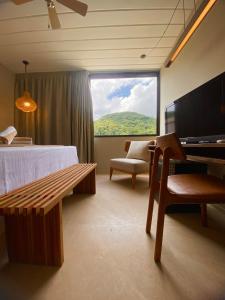 朱奎Pousada Yamandu的客房设有床、长凳和窗户。