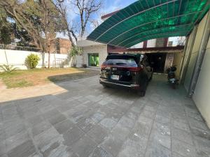 伊斯兰堡Cozy Cottage Islamabad的把车停在房子外,带车棚的汽车