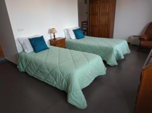维亚纳堡Valentim House的两张位于酒店客房的床,配有蓝色枕头
