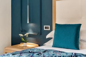 莱万托阿金图公园酒店的一间卧室设有蓝色的墙壁和一张带蓝色枕头的床