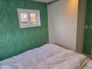 斯卡恩Tinghus Flat的一间卧室设有绿色的墙壁和一张带窗户的床