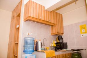 RuiruAdeti Homestay的厨房配有木制橱柜和位于柜台的蓝色水壶