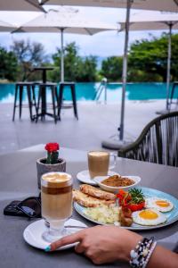 PelindabaLa Joya Lodge Conference Centre and Spa的一张桌子,上面放着一盘食物和两杯咖啡
