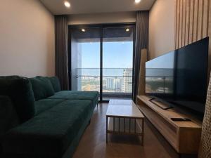 胡志明市luxurious apartment close to city center的客厅配有绿色沙发和大屏幕平面电视