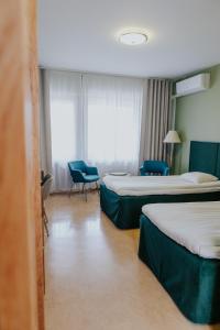 萨洛费加拉酒店的酒店客房,配有两张床和两把椅子