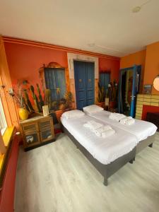 格罗宁根思迪因斯塔德酒店的一间卧室配有一张带橙色墙壁的大床