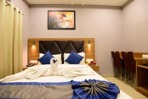 古瓦哈提Click Hotel Guwahati的一间卧室配有一张带蓝色枕头的大床
